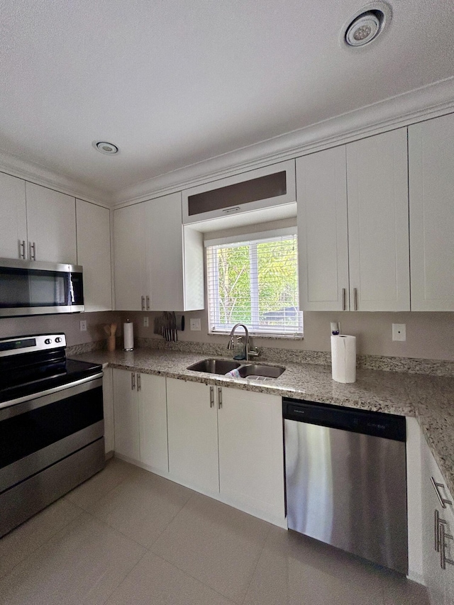 kitchen featuring light tile patterned floors, appliances with stainless steel finishes, sink, and white cabinets