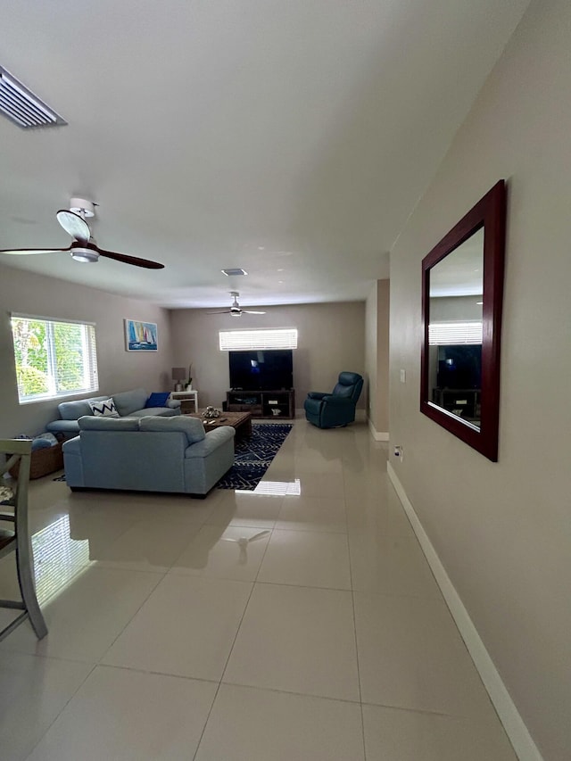 living room with ceiling fan and tile patterned floors