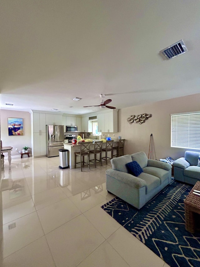 tiled living room with ceiling fan