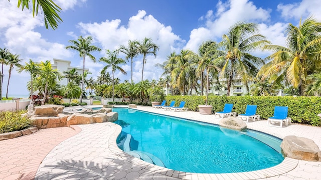 view of pool featuring a fenced in pool, a patio area, and an in ground hot tub