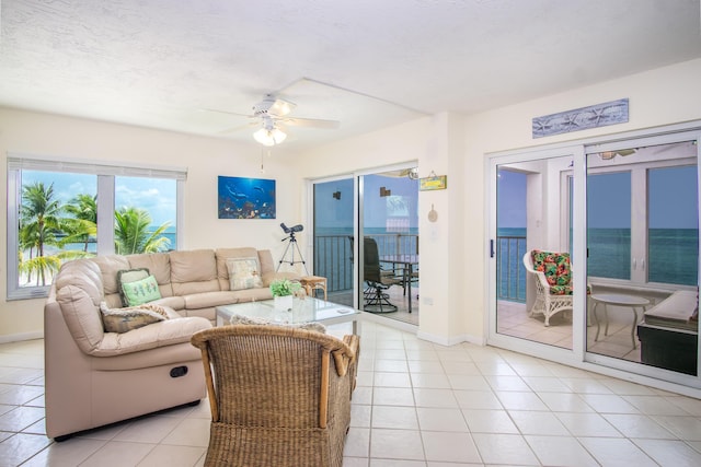 living room featuring baseboards, ceiling fan, and light tile patterned flooring