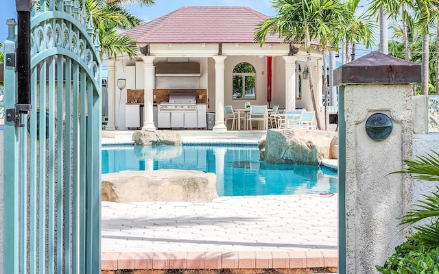 outdoor pool featuring area for grilling, a patio, a gazebo, and a grill