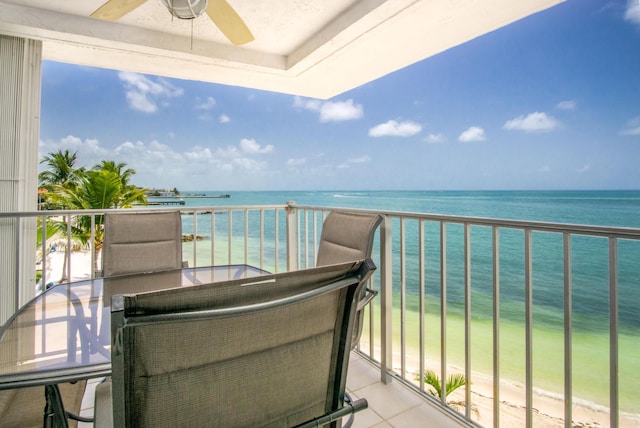 balcony with a ceiling fan and a water view