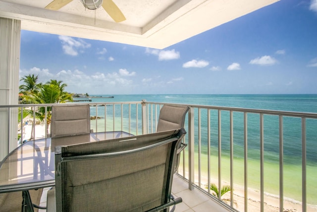 balcony featuring a water view and ceiling fan