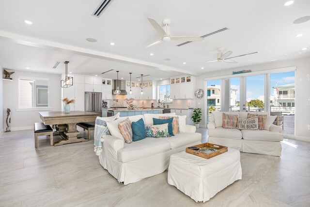 living room with sink, ceiling fan, and french doors