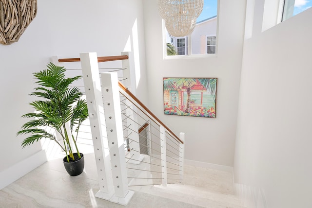 stairs featuring a notable chandelier and a high ceiling