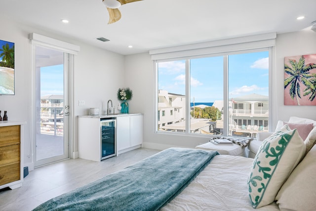 bedroom with wine cooler, wet bar, and access to outside