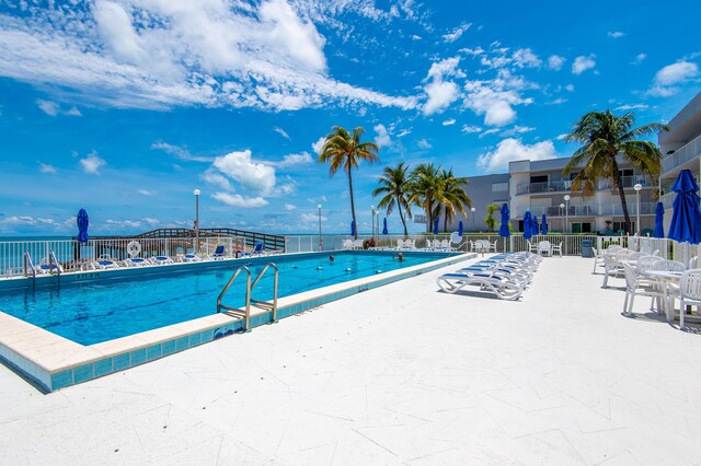 view of pool featuring a patio area and a water view