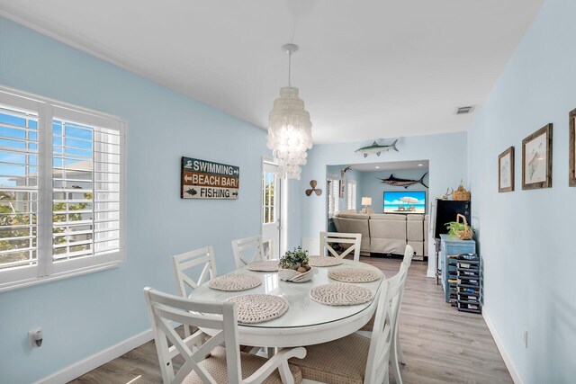 dining space with a notable chandelier and light wood-type flooring