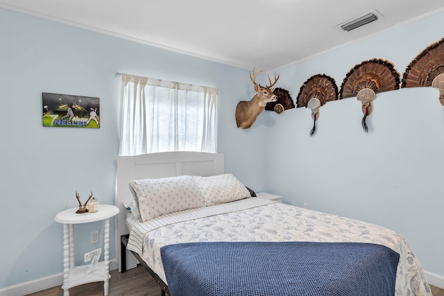 bedroom featuring hardwood / wood-style flooring and ornamental molding