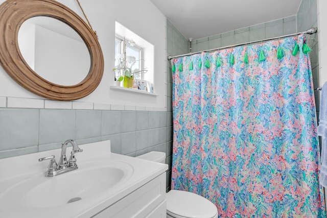 bathroom with tile walls, vanity, toilet, and a shower with shower curtain