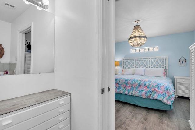 bedroom featuring wood-type flooring and a notable chandelier