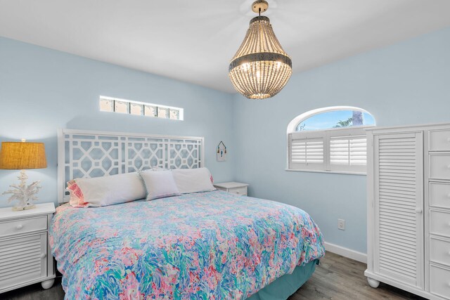 bedroom featuring dark hardwood / wood-style floors and a notable chandelier