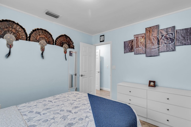 bedroom featuring crown molding and light wood-type flooring