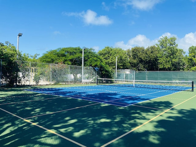 view of tennis court featuring fence