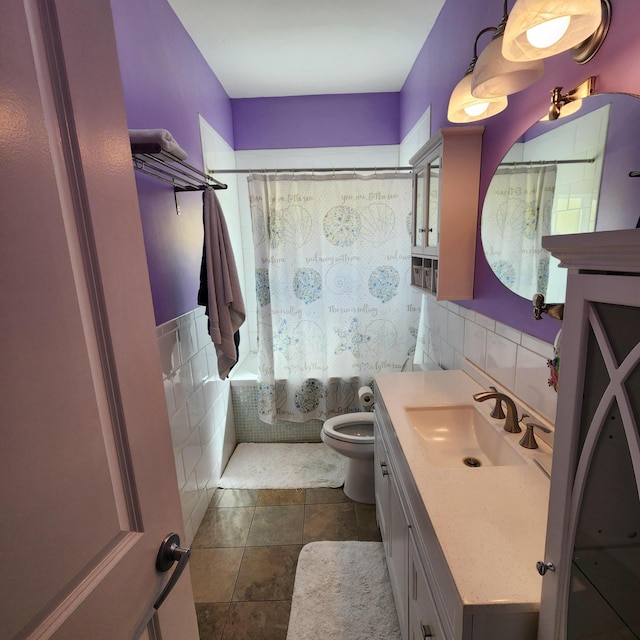 full bathroom featuring shower / bathtub combination with curtain, tile patterned flooring, tile walls, vanity, and toilet