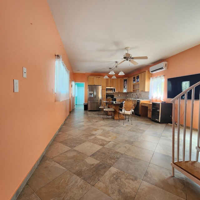 living area with baseboards, plenty of natural light, a ceiling fan, and a wall unit AC