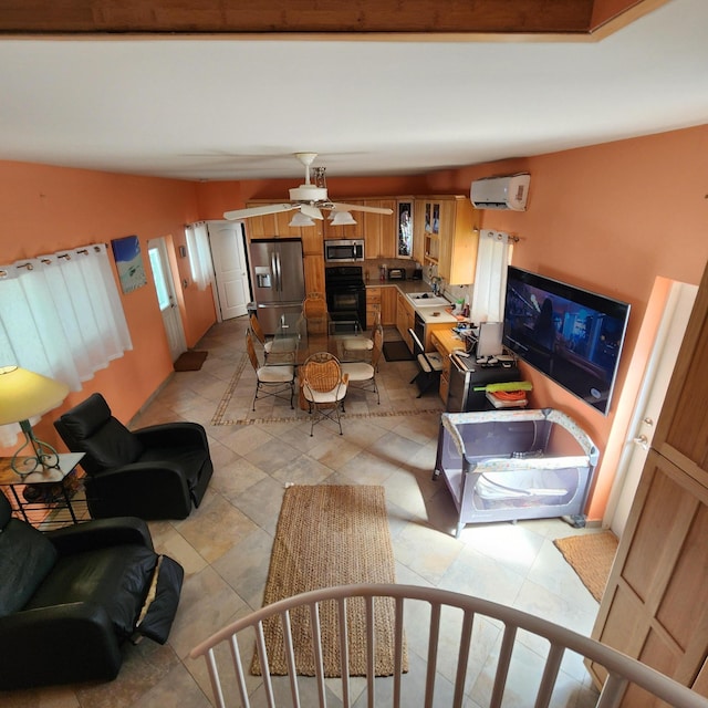 living room with sink, a wall mounted air conditioner, light tile patterned floors, ceiling fan, and a fireplace