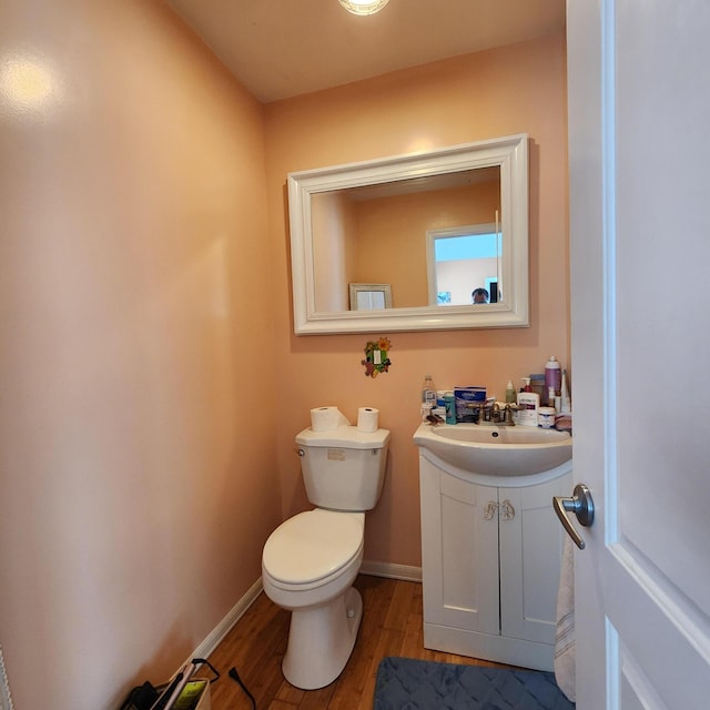 bathroom with hardwood / wood-style flooring, vanity, and toilet