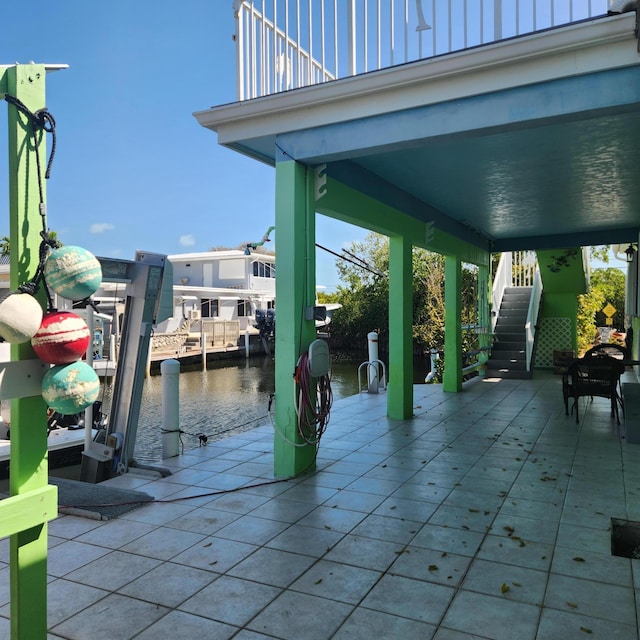view of patio / terrace with a boat dock, stairs, and a water view