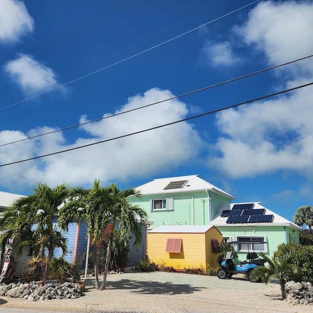 view of front of property with gravel driveway and solar panels