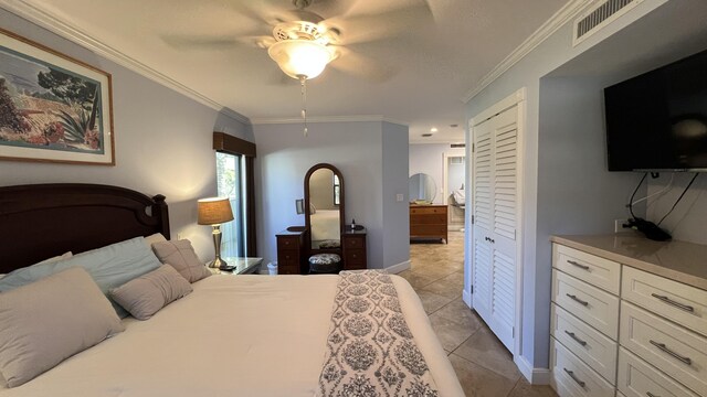 bedroom featuring crown molding, light tile patterned floors, ceiling fan, and a closet