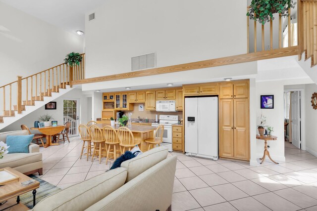 tiled living room featuring sink and a towering ceiling