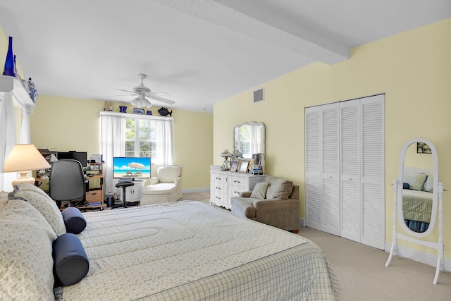 carpeted bedroom with beam ceiling, a closet, and ceiling fan