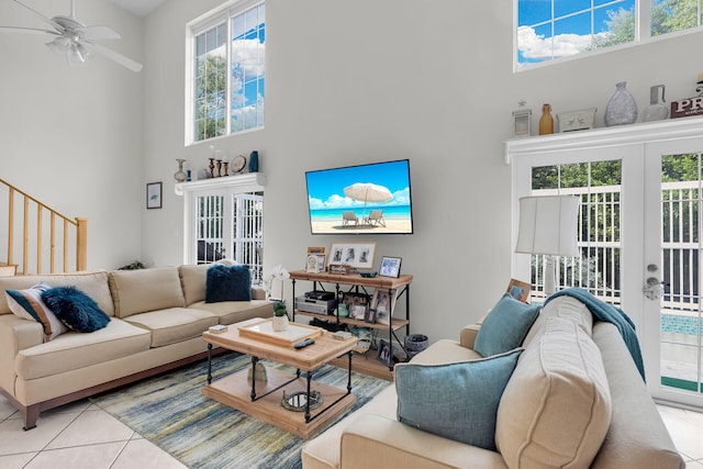 tiled living room featuring a high ceiling, ceiling fan, and french doors