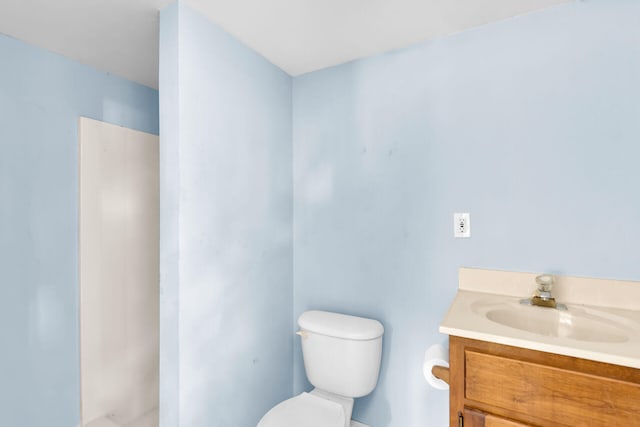 bathroom with vanity, a shower, and toilet