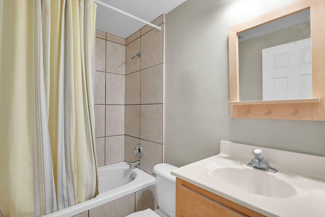 full bathroom with vanity, shower / bath combo with shower curtain, and toilet