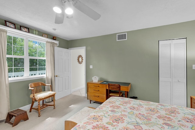 carpeted bedroom featuring a textured ceiling, ceiling fan, and a closet