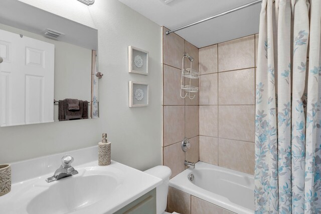 full bathroom featuring shower / tub combo with curtain, vanity, and toilet