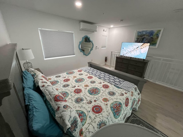 bedroom with an AC wall unit, wood finished floors, recessed lighting, wainscoting, and a decorative wall