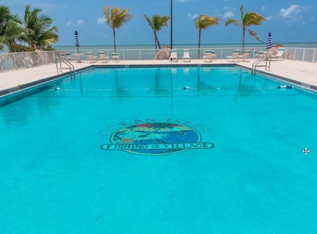 community pool with a patio and fence