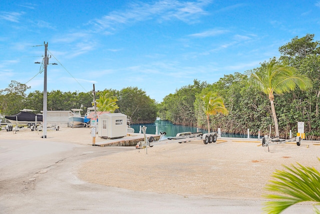 view of property's community with a water view and a storage shed