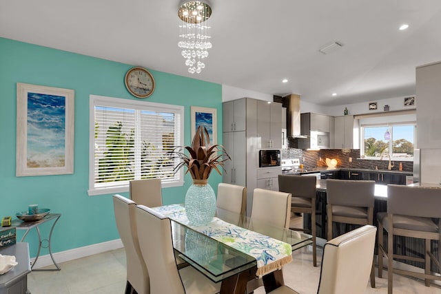 dining area with sink, light tile patterned floors, and a chandelier