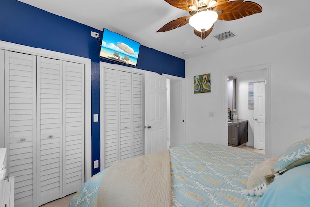 bedroom with ceiling fan, multiple closets, and ensuite bathroom