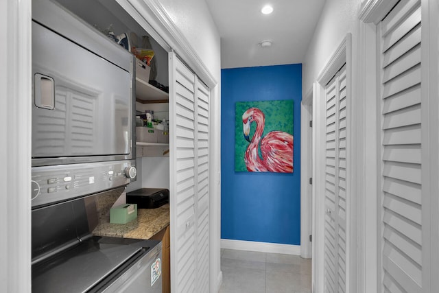 kitchen featuring stacked washer and clothes dryer and light tile patterned floors