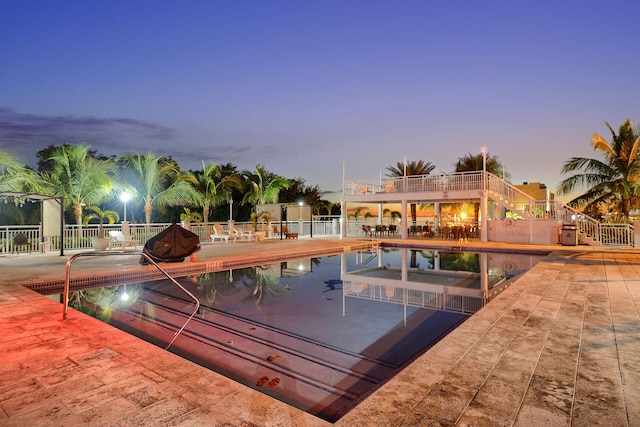 pool at dusk with a patio