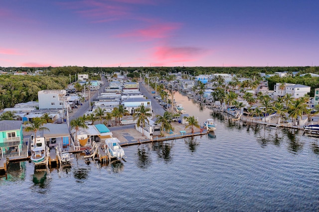 aerial view at dusk featuring a water view