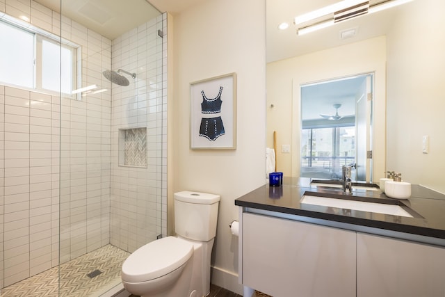 bathroom featuring vanity, toilet, and a tile shower