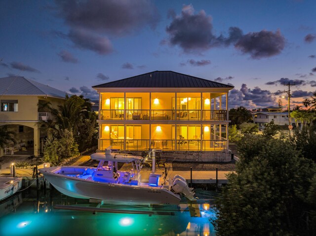 back house at dusk featuring a balcony