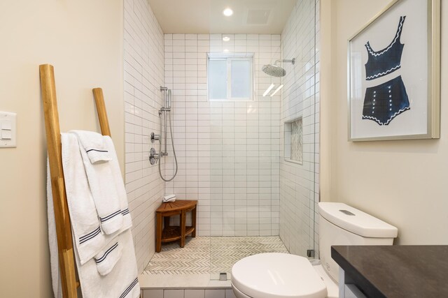 bathroom with tiled shower and toilet