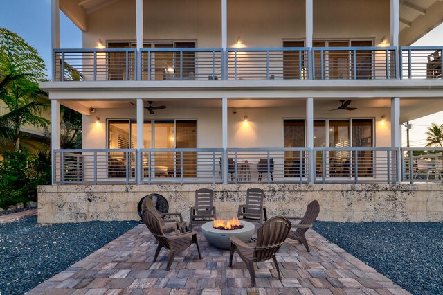 view of patio / terrace featuring a balcony, ceiling fan, and an outdoor fire pit