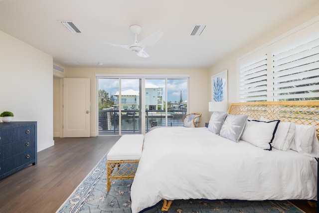 bedroom with a water view, dark wood-type flooring, access to outside, and ceiling fan