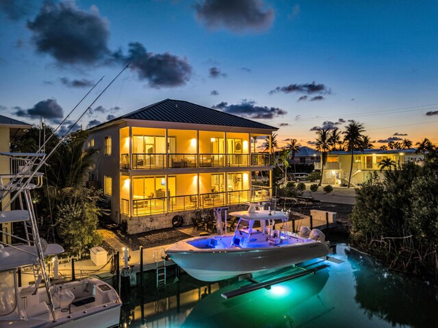 back house at dusk featuring a balcony