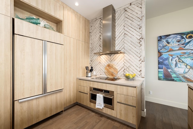 kitchen with wall chimney exhaust hood, stainless steel oven, paneled built in refrigerator, light brown cabinets, and black electric stovetop