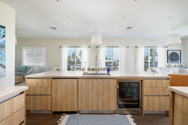 kitchen with sink, a wealth of natural light, wine cooler, and dark wood-type flooring