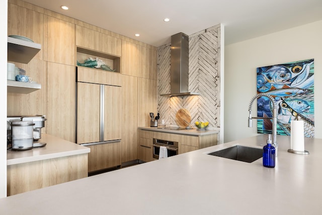 kitchen with wall chimney range hood, sink, black electric cooktop, light brown cabinetry, and stainless steel oven